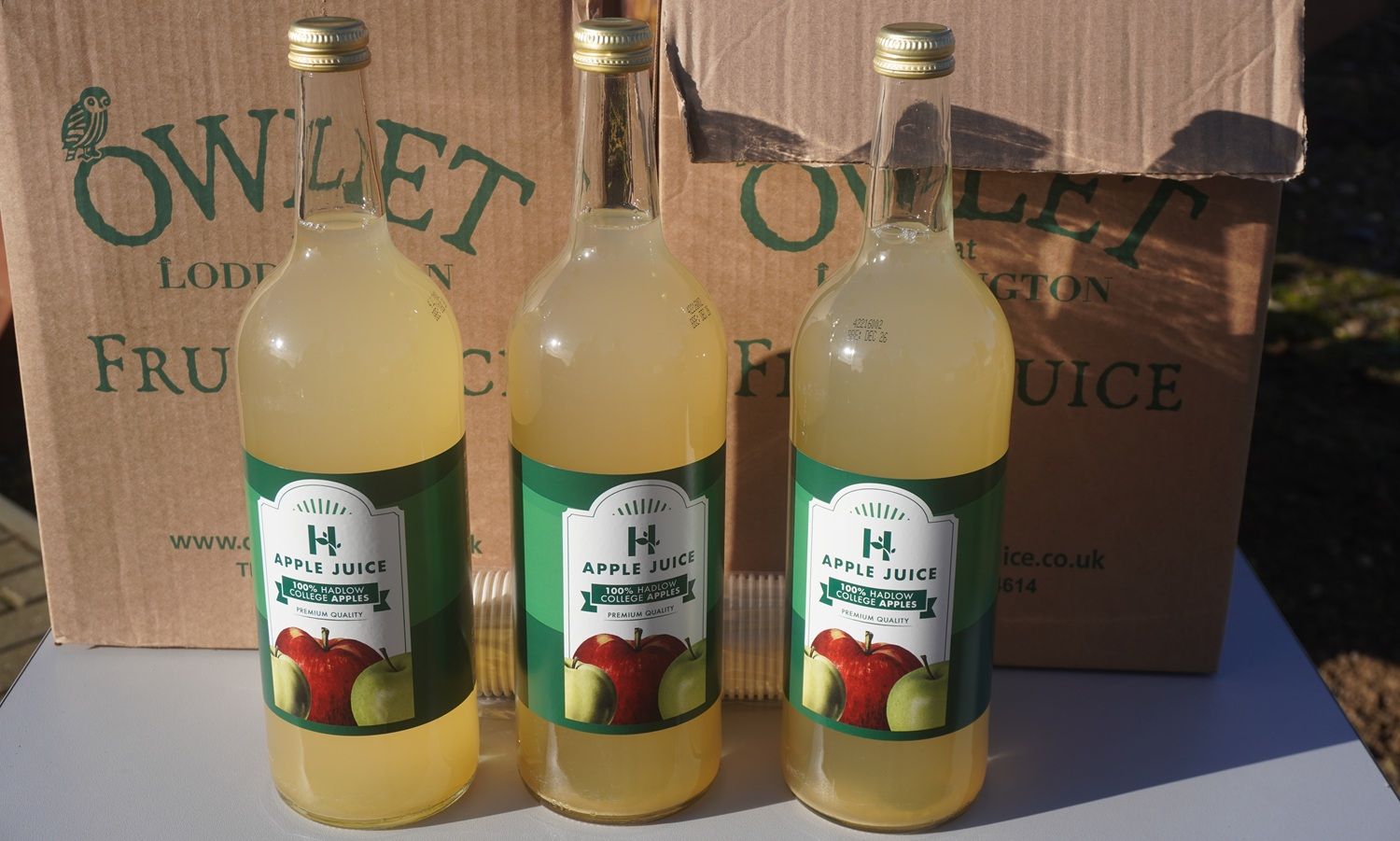 Bottles of Apple Juice in front of cardboard box