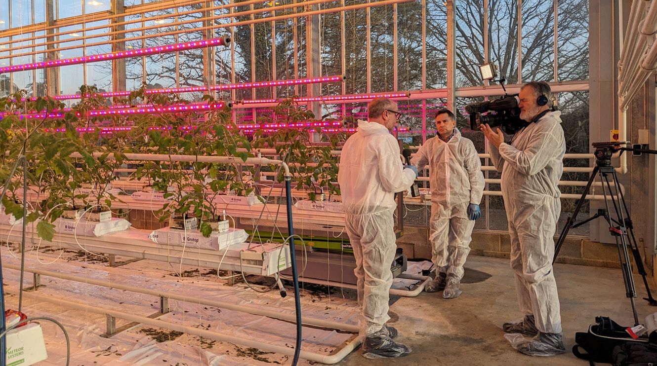 Camera man and presenter in greenhouse